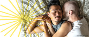 Two men cuddling in bed while sleeping