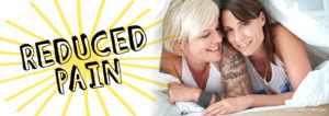 Two women smiling, cuddled under a bed sheet. Text says "reduced pain"