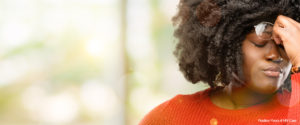 Woman pinching her forehead, looking frustrated